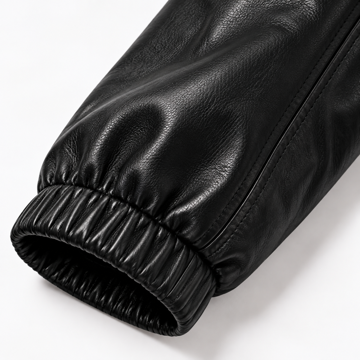 Man wearing black leather jacket with gold zip and black joggers
