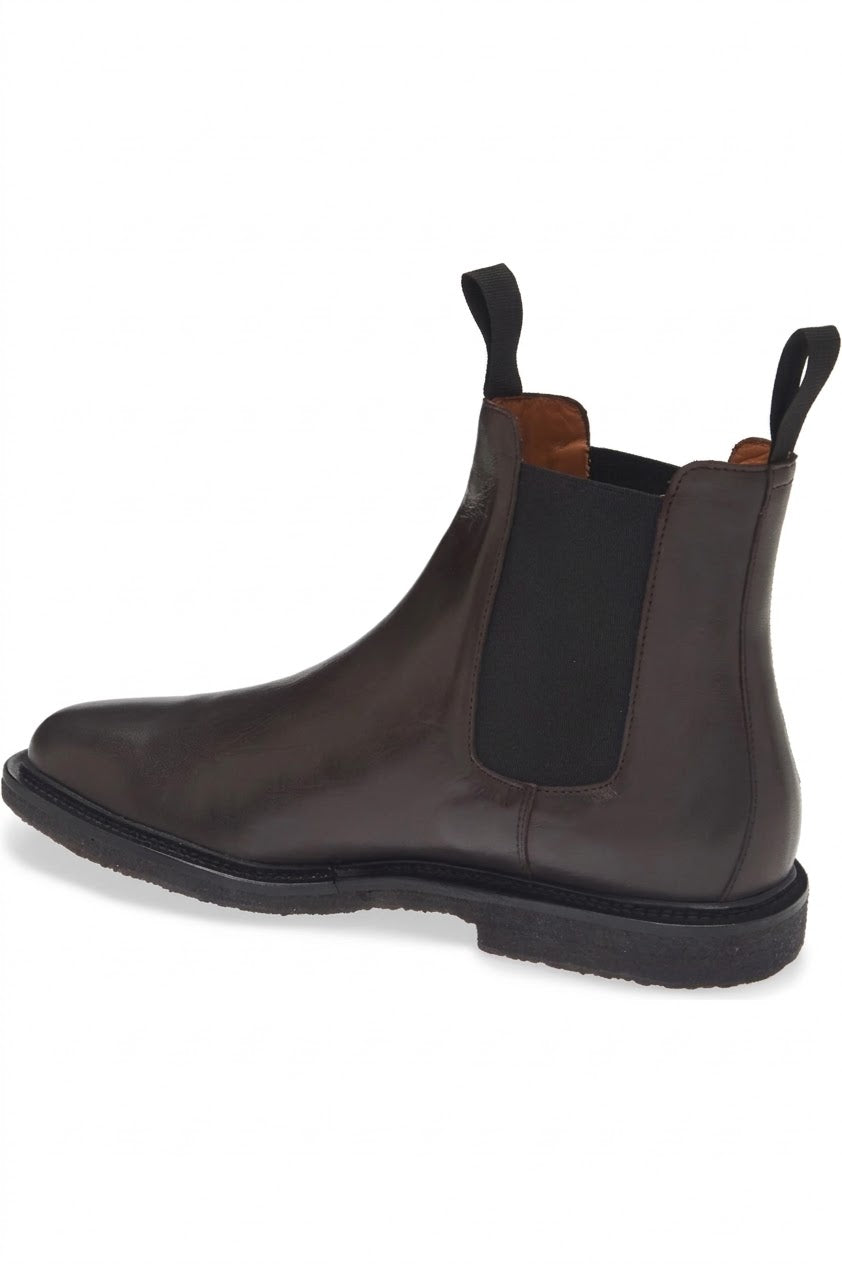 Three-quarter view of dark brown leather Chelsea boot with pull tabs