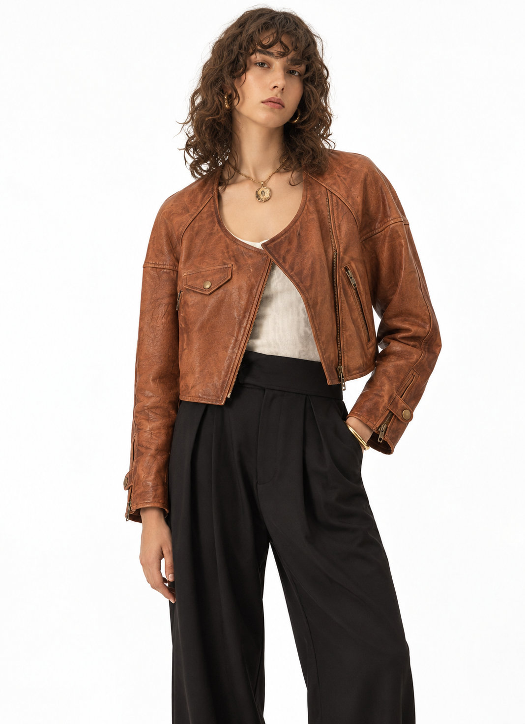 Model wearing women's cognac brown leather moto jacket with black wide-leg trousers