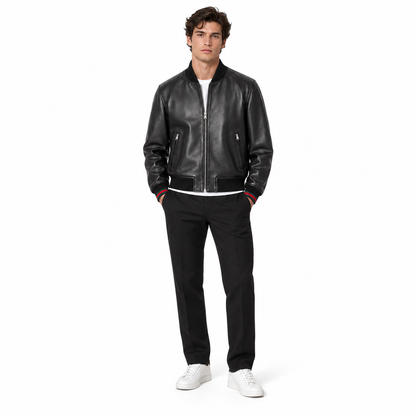 Man wearing black leather bomber jacket with red-tipped trim and white sneakers