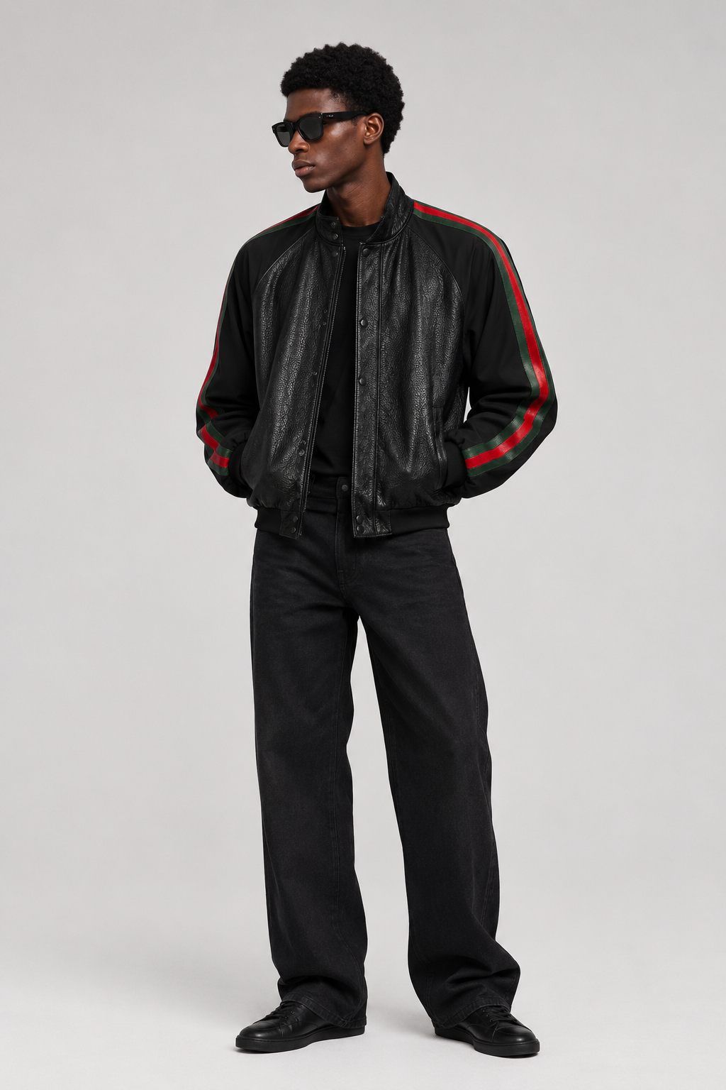 Man wearing black leather striped-sleeve bomber jacket with black trousers