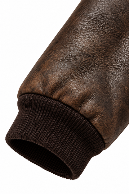 Close-up of ribbed cuff on distressed brown leather bomber sleeve